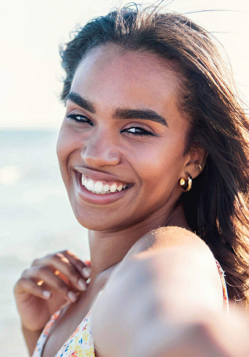 Beautiful woman taking a selfie at the beach