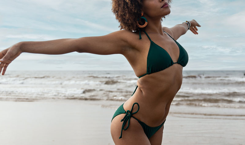 Woman at the beach with her arms stretched out