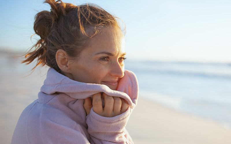 Woman keeping herself warm on the beach